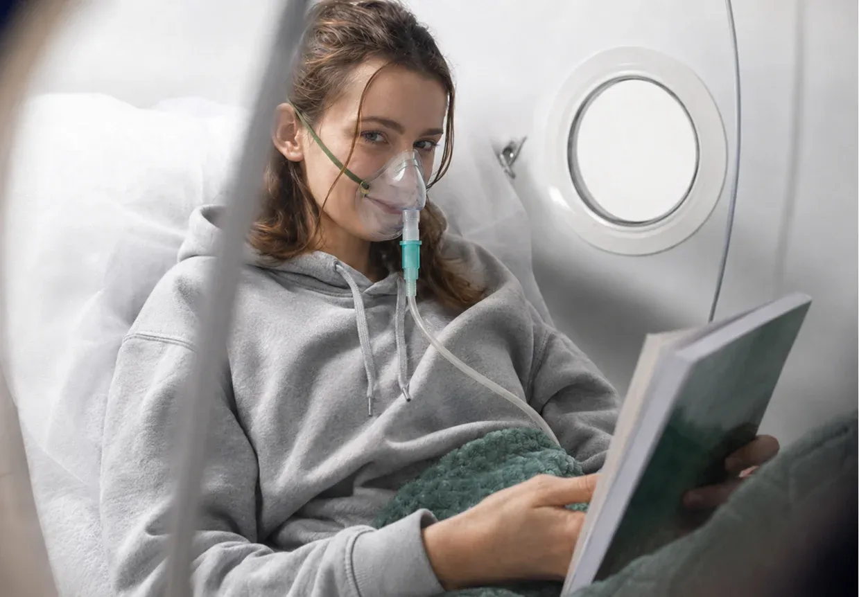 A person relaxing and reading inside a Superhuman S1 soft-shell hyperbaric chamber