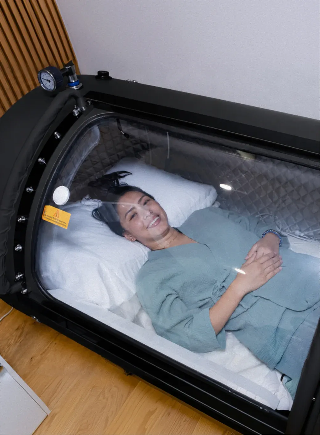 A woman lying flat on the mattress inside a Superhuman L1, its door open