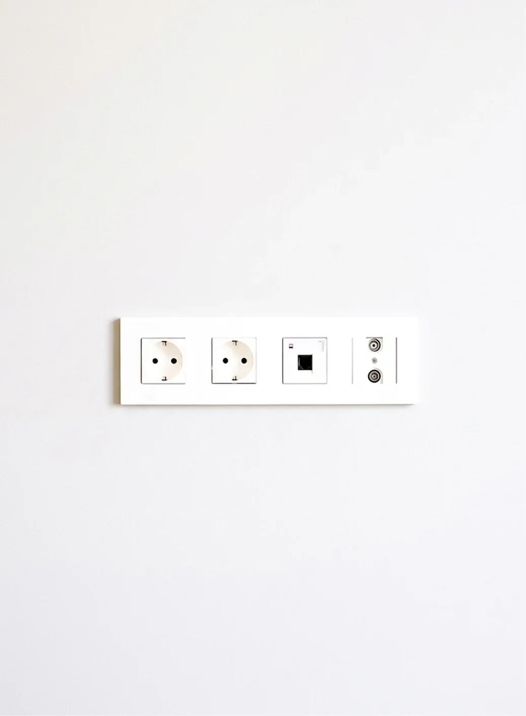 A standard wall socket plate on a plain white wall
