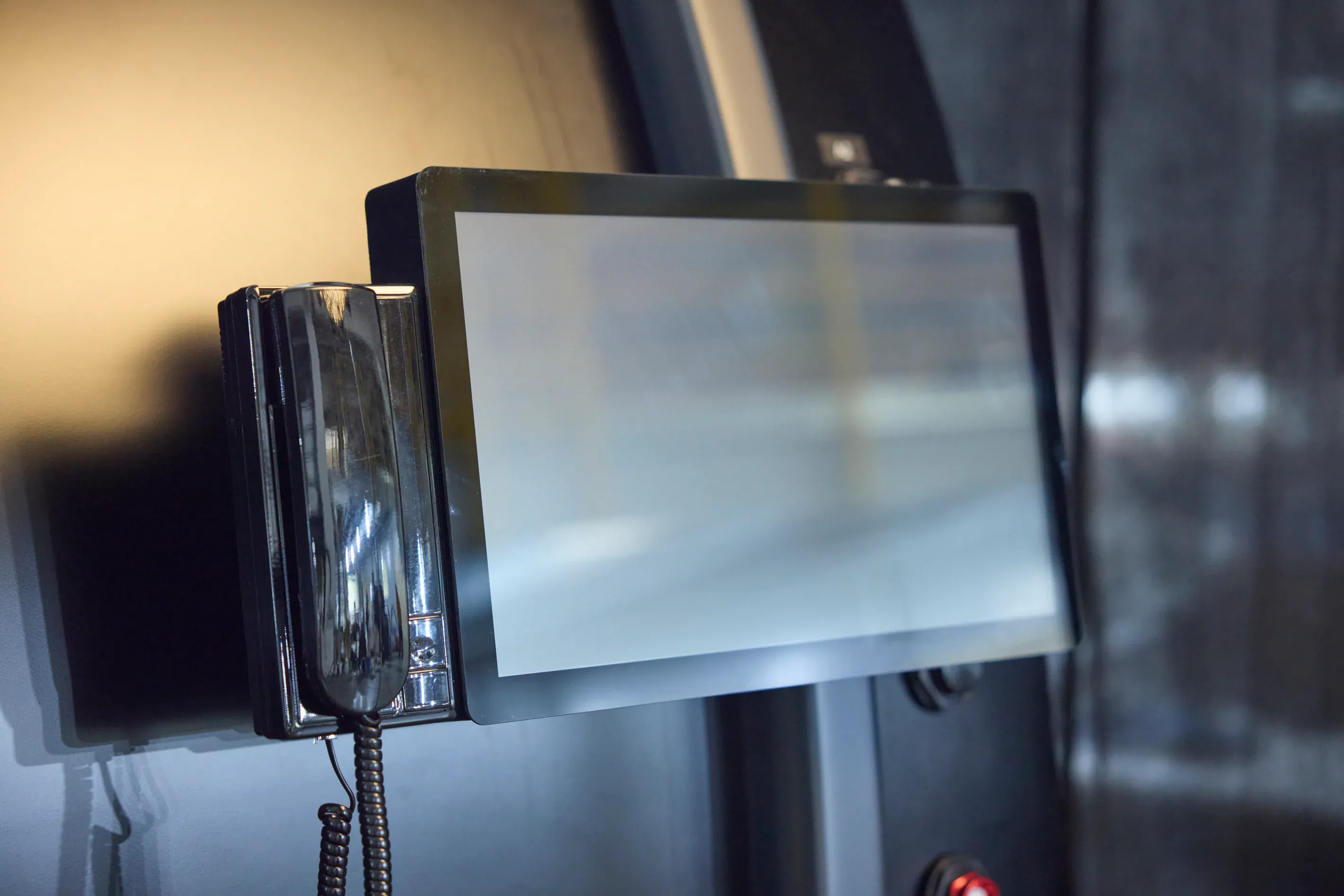 The intercom handset mounted beside the screen on the outside of a Superhuman chamber