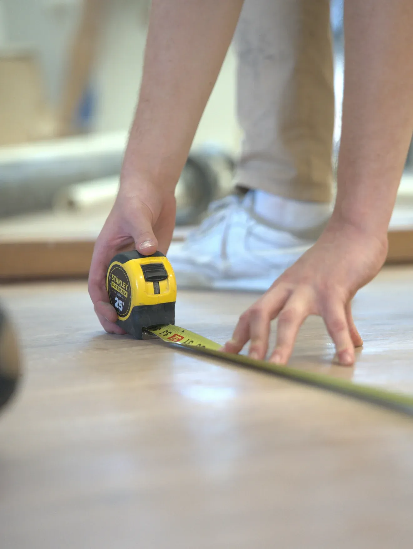 A tape measure pulled across the floor of the room where the chamber will go