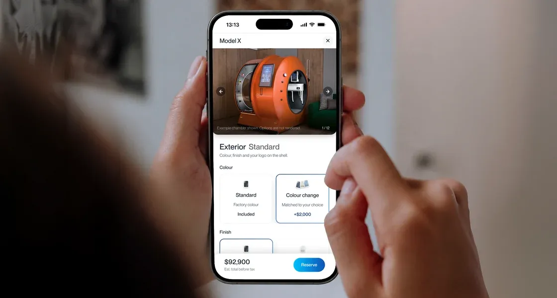 Two hands holding a phone that shows the X configurator and its color options